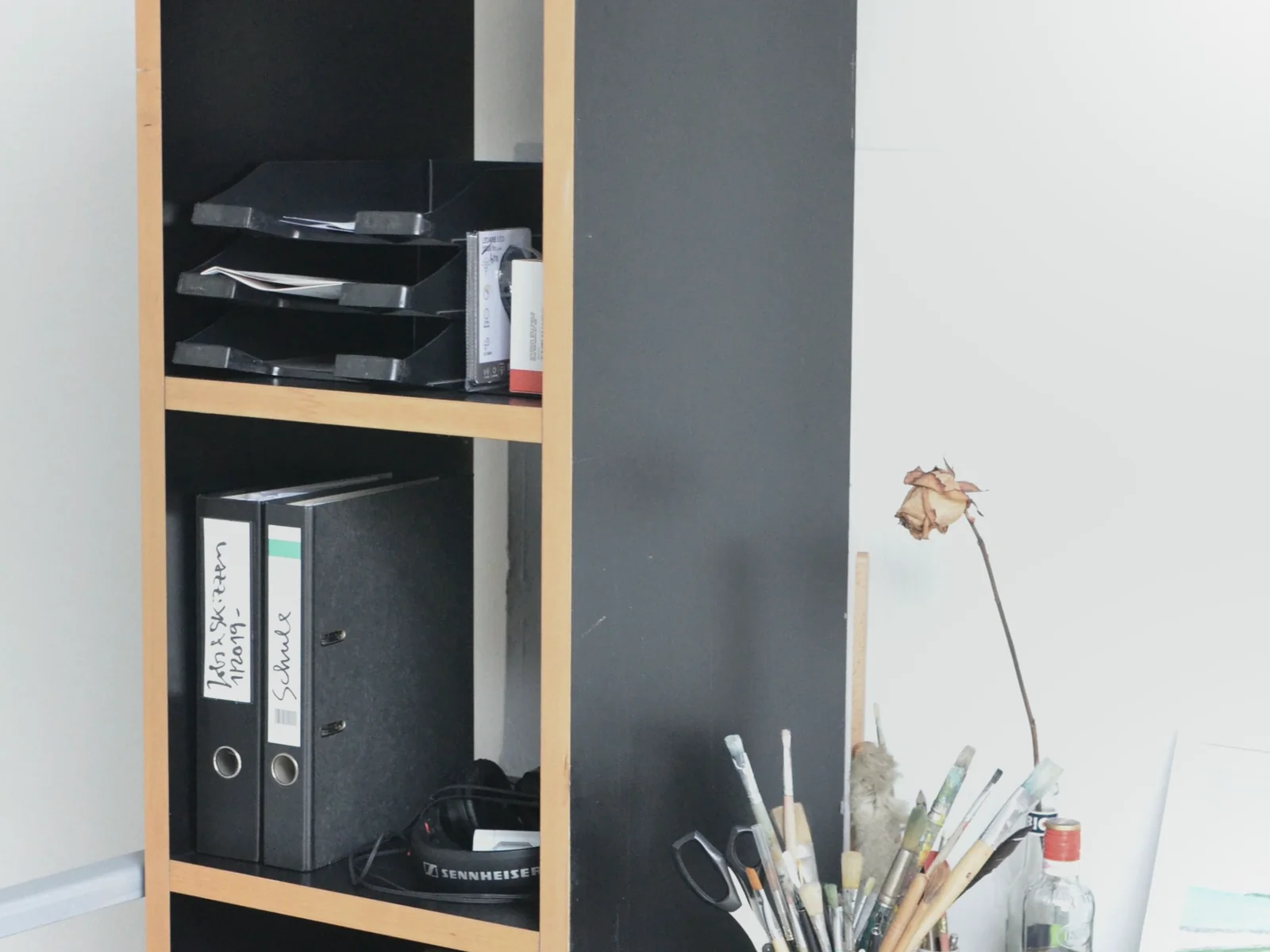 Binders and document trays arranged on an open home shelf