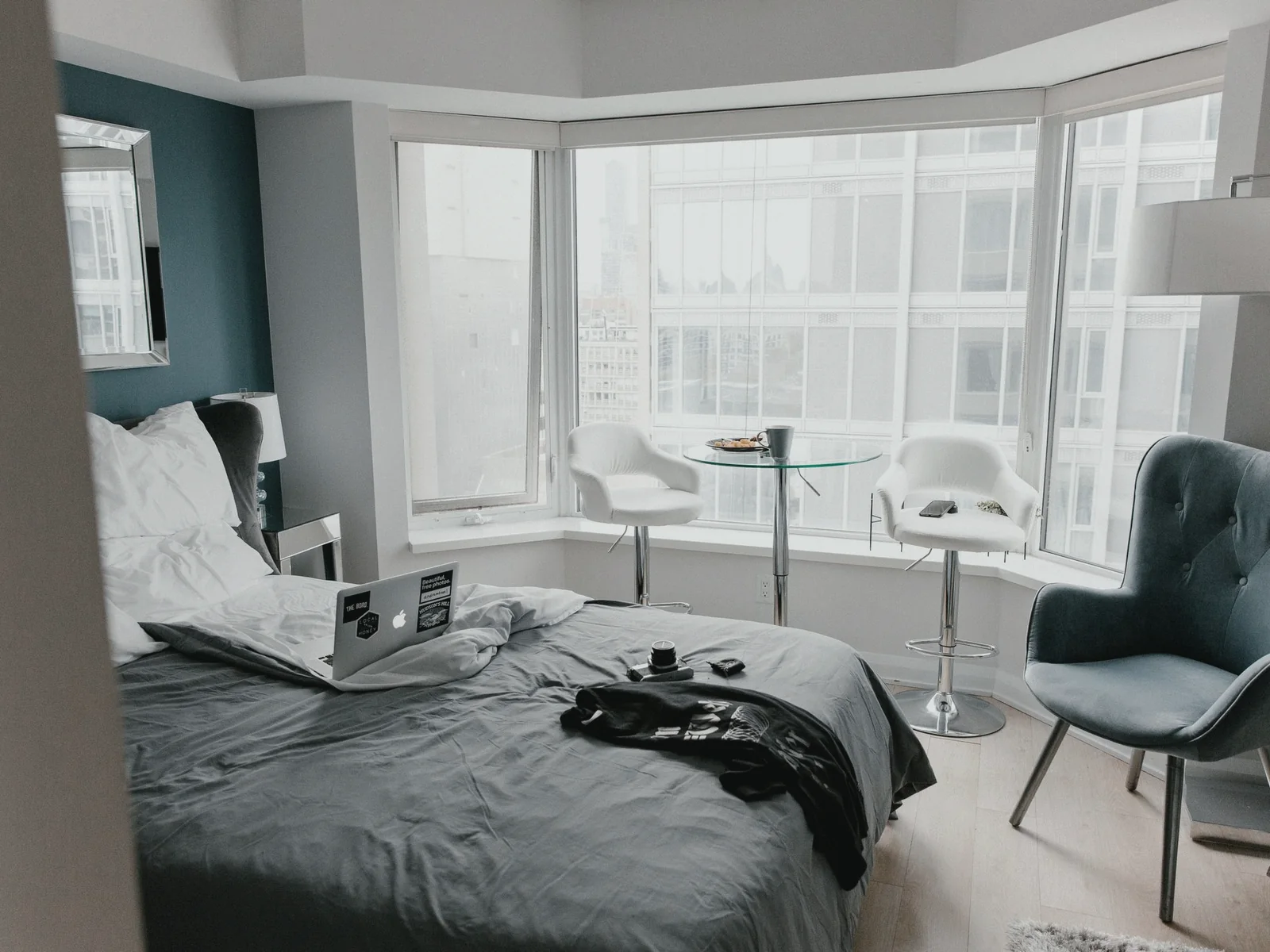 Bright hotel room with a laptop and personal items on the bed
