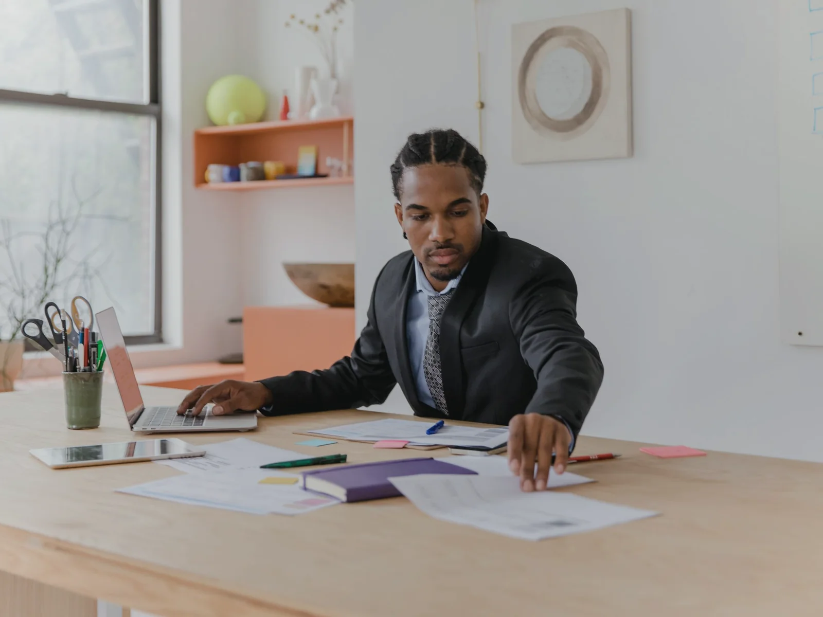 Adult arranging papers and notes across a work desk